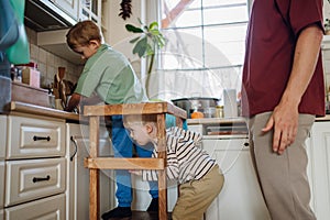 Family preparing breakfast in home kitchen in the morning. Spending time together before going to school and work.