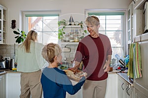 Family preparing breakfast together in home kitchen. Healthy breakfast or snack before kindergarden, school and work.