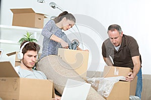 family preparing cardboard boxes idle boy on laptop