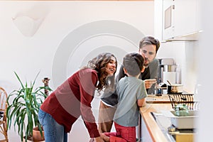 Family preparing and eating peanut chocolate cookies at home