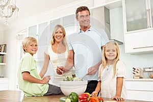 Family Preparing Salad In Modern Kitchen