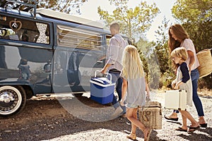 Family preparing their camper van for a road trip, side view