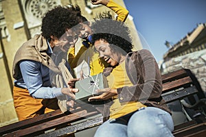 Family with present outdoor.Father and daughter giving a gift box to mother