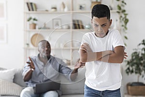 Family problems. Angry black grandfather shouting at his grandson at home