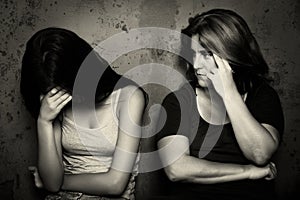Teenage girl cries next to her angry and worried mother photo