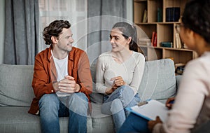 Family psychological therapy. Cheerful millennial european guy and woman listen doctor at meeting