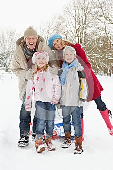 Family Pulling Sledge Through Snowy Landscape