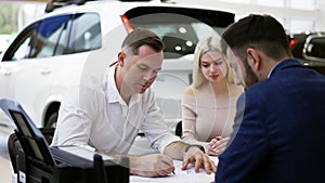 Family purchase of a new car, signing the contract in the showroom