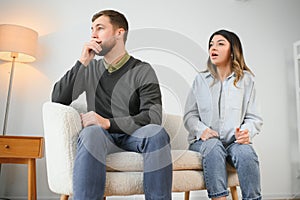 Family quarrel, man and woman sitting on sofa at home. angry woman yells at her husband