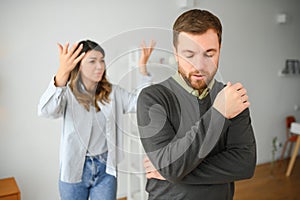 Family quarrel, man and woman sitting on sofa at home. angry woman yells at her husband