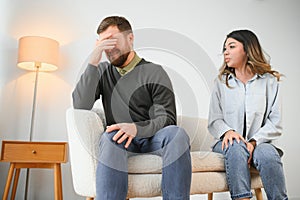 Family quarrel, man and woman sitting on sofa at home. angry woman yells at her husband