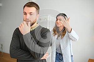 Family quarrel, man and woman sitting on sofa at home. angry woman yells at her husband