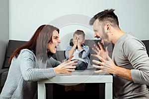 Family quarrel, poma and dad swear in the background of the son who does not like it, the child cries. The concept of family