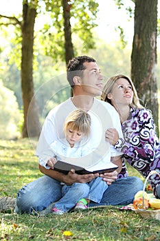 Family read the Bible in nature