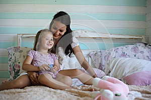 Family reading bedtime. Pretty young mother reading a book to daughter.