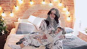 Family reading bedtime. Pretty young mother reading a book to her daughters.