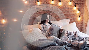 Family reading bedtime. Pretty young mother reading a book to her daughters.