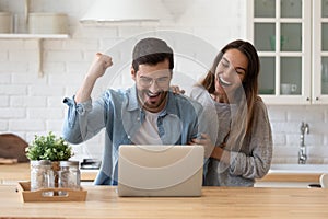 Family reading e-mail from bank on laptop celebrate loan approval