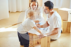 Family reading instruction and assemble furniture together at living room of new apartment pile of moving boxes on