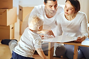 Family reading instruction and assemble furniture together at living room of new apartment pile of moving boxes on