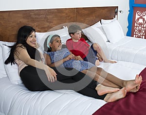 Family reclining smiling at television.