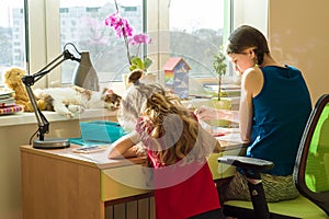 Family, recreation, creativity, home. Girls sisters at home at the table paint with watercolor