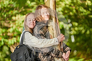 Family relationships. Teenager and mother relaxing together near tree