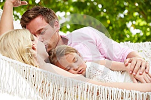 Family Relaxing In Beach Hammock