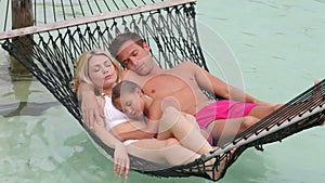 Family Relaxing In Beach Hammock