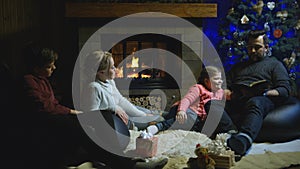 Family relaxing in front of the Christmas tree