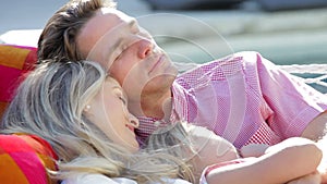 Family Relaxing In Garden Hammock Together