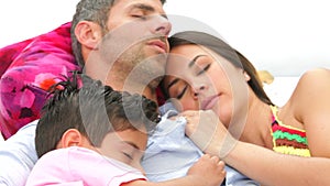 Family Relaxing In Garden Hammock Together