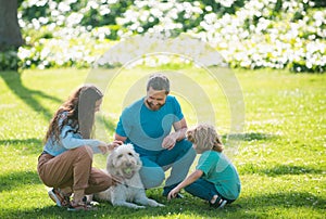 Family relaxing in garden with pet dog. The concept of a happy family. Parents and children on vacation playing together