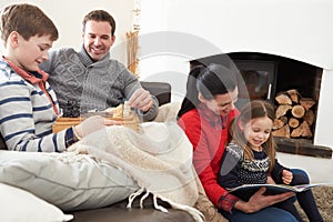 Family Relaxing Indoors Playing Chess And Reading Book