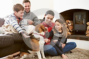 Family Relaxing Indoors And Stroking Pet Dog photo