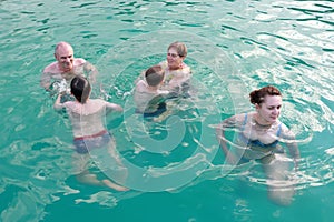 Family relaxing in open pool