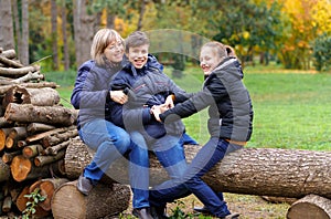 Family relaxing outdoor in autumn city park, happy people together, parents and children, they talking and smiling, beautiful