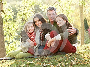 Family Relaxing Outdoors In Autumn Landscape
