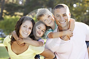 Family Relaxing In Summer Park