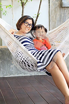 family relaxing time mother and young kid on white clothes cradle