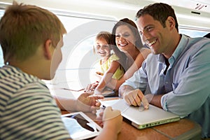 Family Relaxing On Train Journey