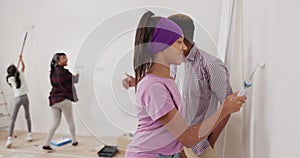 A family renovates an apartment parents and children painting the walls father teaches his daughter how to use a roller