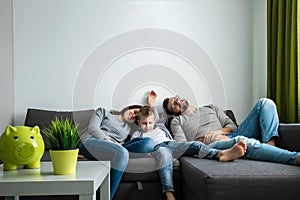 The family is resting on the couch all together. Concept of spending time together, happy family