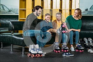 family resting on sofa before skating in roller skates