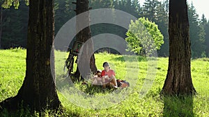 The family rests with bicycles in the summer forest on a sunny day.
