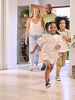 Family Returning Home Opening Front Door And Children Running In