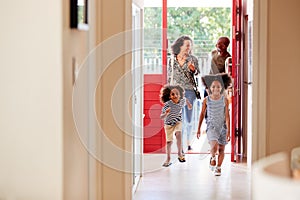 Family Returning Home From Shopping Trip Using Plastic Free Grocery Bags Opening Front Door