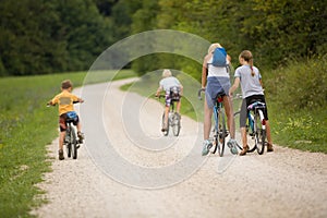 Family ride bikes on country road, outdoor in green environment