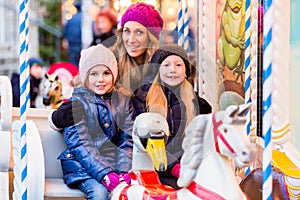 Family riding the carousel on Christmas market