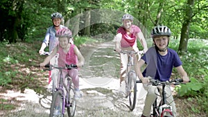 Family Riding Mountain Bikes Along Track